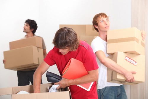 Professional movers carrying items from a flat in New Cross