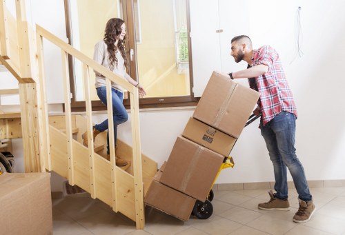 Professional movers carrying items from a flat in New Cross